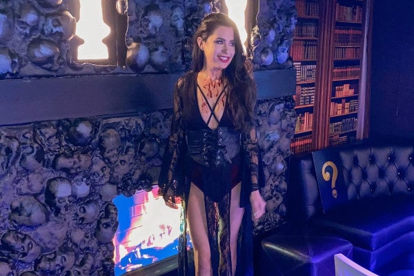 Girl in front fo fireplace with skulls