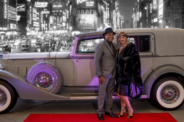 Man and women in front of vintage car